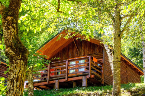 Bungalow Comfort in legno al campeggio Bedura Park in Spagna, circondato da alberi verdi e natura.