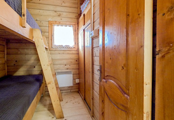 Stanza rivestita in legno con letto a castello nel Bungalow Comfort al campeggio Bedura Park in Spagna.