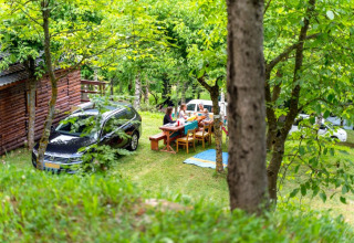 Reunión al aire libre junto a la Bungalow «Zen» en Bedura Park, España, con personas comiendo en una mesa.