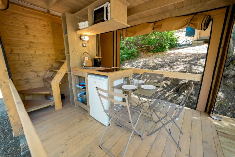 Indvendigt billede af et safari telt ved Vallicella Glamping Resort i Italien med køkken og spiseplads.