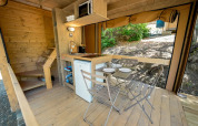 Intérieur de la tente safari Air Dreamer au Vallicella Glamping Resort en Italie, avec cuisine et coin repas.