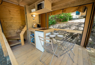 Indvendigt billede af et safari telt ved Vallicella Glamping Resort i Italien med køkken og spiseplads.