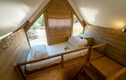 Vue intérieure d’un lit en mezzanine dans une tente safari au Vallicella Glamping Resort, en Italie.