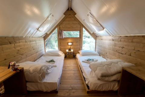 Indretningen af et hyggeligt trætelt med to enkeltsenge på Vallicella Glamping Resort, Italien, Air Dreamer 1.