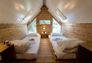 Indretningen af et hyggeligt trætelt med to enkeltsenge på Vallicella Glamping Resort, Italien, Air Dreamer 1.