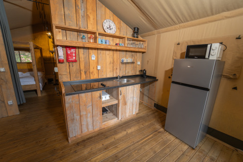Coin cuisine de la Safari Lodge 1 au Vallicella Glamping Resort, bois, réfrigérateur et micro-ondes visibles.