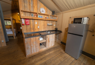 Coin cuisine de la Safari Lodge 1 au Vallicella Glamping Resort, bois, réfrigérateur et micro-ondes visibles.