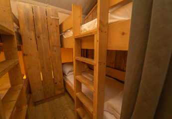 Træ-køjesenge inde i Safari Lodge 1 teltet på Vallicella Glamping Resort i Italien, hyggelig stemning.