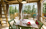 Vue intérieure de la tente safari Air Lodge au Vallicella Glamping Resort en Italie, avec mobilier en bois.