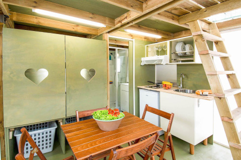 Interieur van een safaritent in Air Lodge, Vallicella Glamping Resort, met keuken en eettafel.