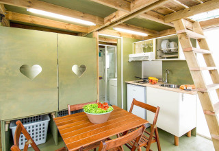 Interieur van een safaritent in Air Lodge, Vallicella Glamping Resort, met keuken en eettafel.