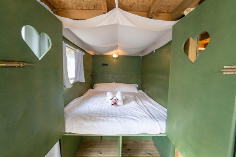 Knus safaritentbed met groene wanden en hartjes bij Vallicella Glamping Resort in Italië.
