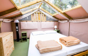 Vue intérieure d'une tente safari Air Lodge au Vallicella Glamping Resort en Italie, avec un lit double.