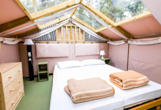 Binnenzicht van een Air Lodge safaritent in Vallicella Glamping Resort, Italië, met een tweepersoonsbed.