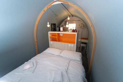 Indretning af et glamping-værelse ved navn Coco Couple, med en dobbeltseng og indbydende atmosfære.