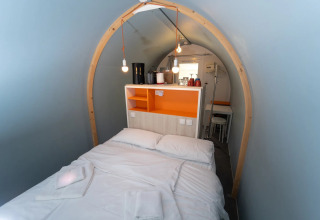 Indretning af et glamping-værelse ved navn Coco Couple, med en dobbeltseng og indbydende atmosfære.
