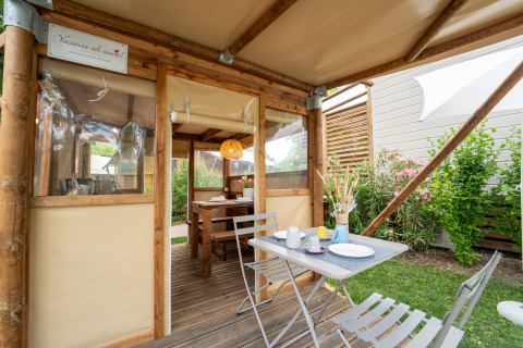 Tente safari « Air Stay XL » au Vallicella Glamping Resort en Italie, coin repas extérieur et ambiance chaleureuse.