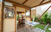 Tente safari « Air Stay XL » au Vallicella Glamping Resort en Italie, coin repas extérieur et ambiance chaleureuse.