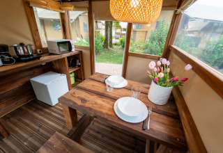 Intérieur chaleureux d’une tente safari équipée d’une cuisine en bois à l’Air Stay XL, Vallicella Glamping Resort, Italie.