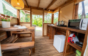 Intérieur de la tente safari « Air Stay » XL au Vallicella Glamping Resort en Italie, avec table et kitchenette.