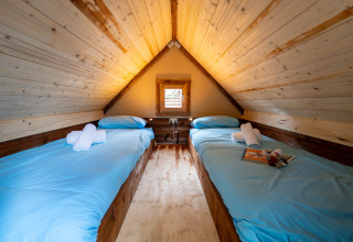 Chambre mansardée avec deux lits simples dans la tente safari Air Stay XL au Vallicella Glamping Resort.
