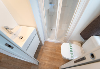 Salle de bain avec douche, WC et lavabo dans le Cottage Next XL supérieur au Vallicella Glamping Resort, Italie.