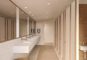 Baño moderno de tienda safari con suelo de madera, lavabos, espejos, puertas y cesta de mimbre.