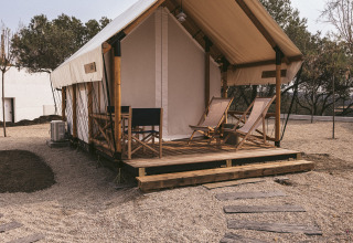Safaritent bij Wecamp Cadaqués in Spanje met houten terras, ligstoelen en grindpad erboven.