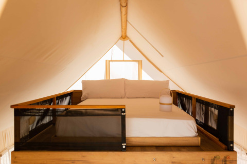 Tweepersoonsbed op mezzanine in een luxe safaritent, Glamping Family Plus bij Wecamp Cadaqués, Spanje.