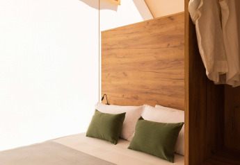 Interno di una tenda safari Glamping Family Plus a Wecamp Cadaqués in Spagna, con un letto accogliente.