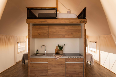 Moderne kitchenette en mezzaninebed in een Glamping Family Plus safaritent bij Wecamp Cadaqués, Spanje.
