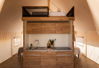 Moderne kitchenette en mezzaninebed in een Glamping Family Plus safaritent bij Wecamp Cadaqués, Spanje.