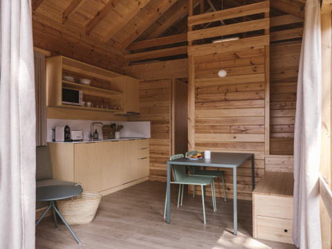 Vista interior de la moderna tiny house Bungalow «Duplex» en Wecamp Cala Montgó, España, con diseño en madera.