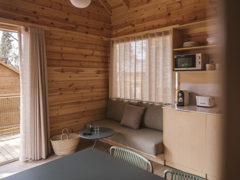 Acogedor interior de la Bungalow Duplex en Wecamp Cala Montgó, España, con sofá y cocina pequeña.