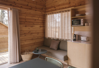 Acogedor interior de la Bungalow Duplex en Wecamp Cala Montgó, España, con sofá y cocina pequeña.