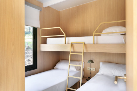 Kamer in MOBIL HOME FAMILY PLUS bij Wecamp Cala Montgó, Spanje, met stapelbed en twee eenpersoonsbedden.