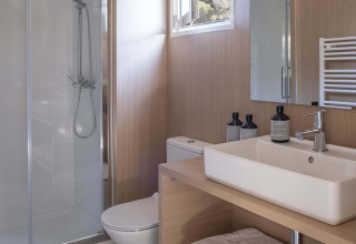 Moderne badkamer met douche en hout in een MOBIL HOME FAMILY PLUS bij Wecamp Cala Montgó, Spanje.