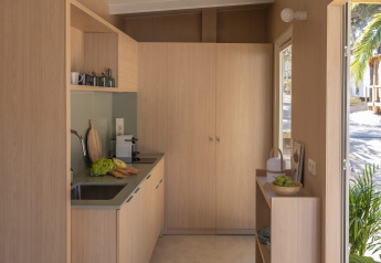Moderne, lichte kitchenette in de MOBILE HOME FAMILY bij Wecamp Cala Montgó, Spanje, met houten accenten.
