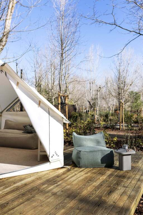Tente safari Bell au Wecamp San Sebastián, Espagne. Coin salon confortable sur terrasse en bois, vue nature.