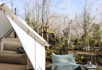 Tente safari Bell au Wecamp San Sebastián, Espagne. Coin salon confortable sur terrasse en bois, vue nature.
