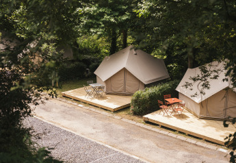 Tentes safari lumineuses sur terrasses en bois à Wecamp San Sebastián, Espagne, dans un cadre verdoyant.