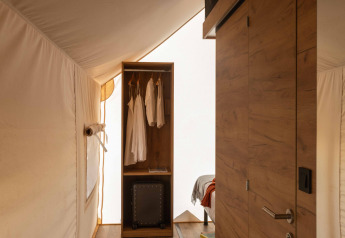 Vista interna della tenda safari Glamping Family Plus al Wecamp San Sebastián, Spagna, con dettagli in legno.