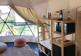 Interieur van een dome bij Wecamp Cabo de Gata, Spanje, met koffiezetapparaat, vloerkleed en zitkussens.