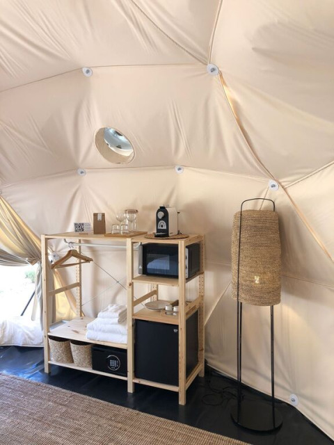 Interieur van een Domo-koepel bij Wecamp Cabo de Gata in Spanje met planken, lamp en moderne voorzieningen.