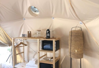 Interieur van een Domo-koepel bij Wecamp Cabo de Gata in Spanje met planken, lamp en moderne voorzieningen.