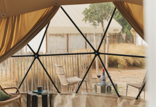 Interieur van de Domo-koepel bij Wecamp Cabo de Gata, Spanje met zitplek en uitzicht op de buitenomgeving.
