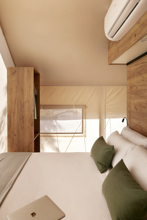 Innenansicht eines luxuriösen Safari-Zeltes bei Wecamp Cabo de Gata mit modernen Holzmöbeln.