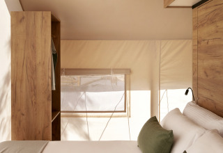 Innenansicht eines luxuriösen Safari-Zeltes bei Wecamp Cabo de Gata mit modernen Holzmöbeln.