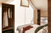 Intérieur d’une tente safari Glamping Comfort à Wecamp Cabo de Gata, Espagne, avec lit et rangements.