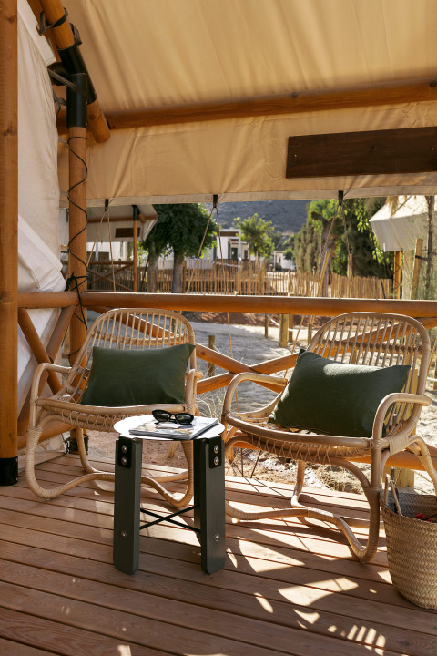 Dos sillas de mimbre y una mesa pequeña en la terraza del Glamping Comfort en Wecamp Cabo de Gata, España.